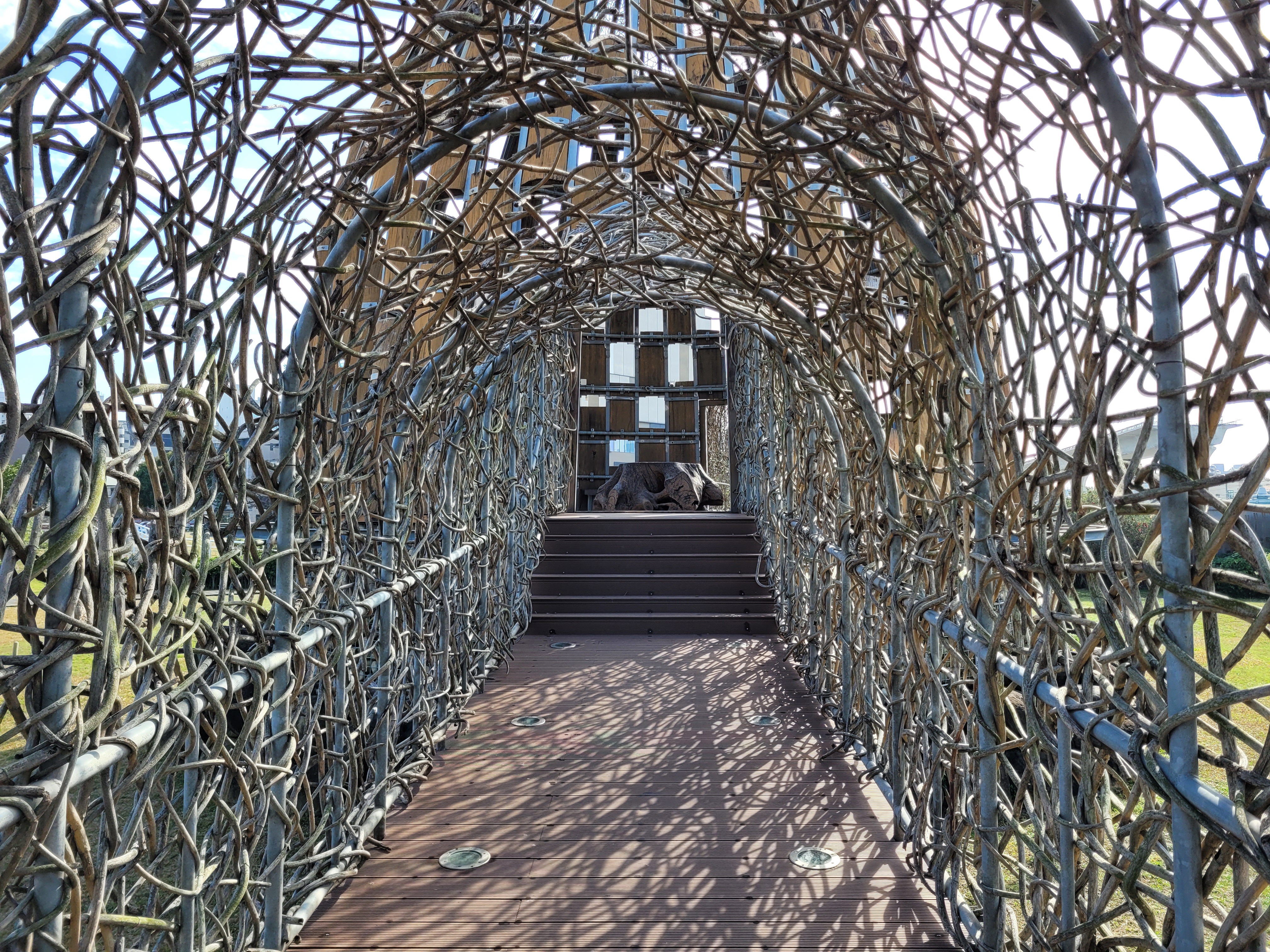 05/03/2025 - Song of the Forest -
					Song of the Forest is an installation in Chiayi that symbolizes the sacred tree, the tunnel, and the track of Alishan Forest Railway to show the transition of light and the magnificence of Alishan.
					It was created by the artist Wang Wen-Chih in 2011 using wood from the Alishan forest.