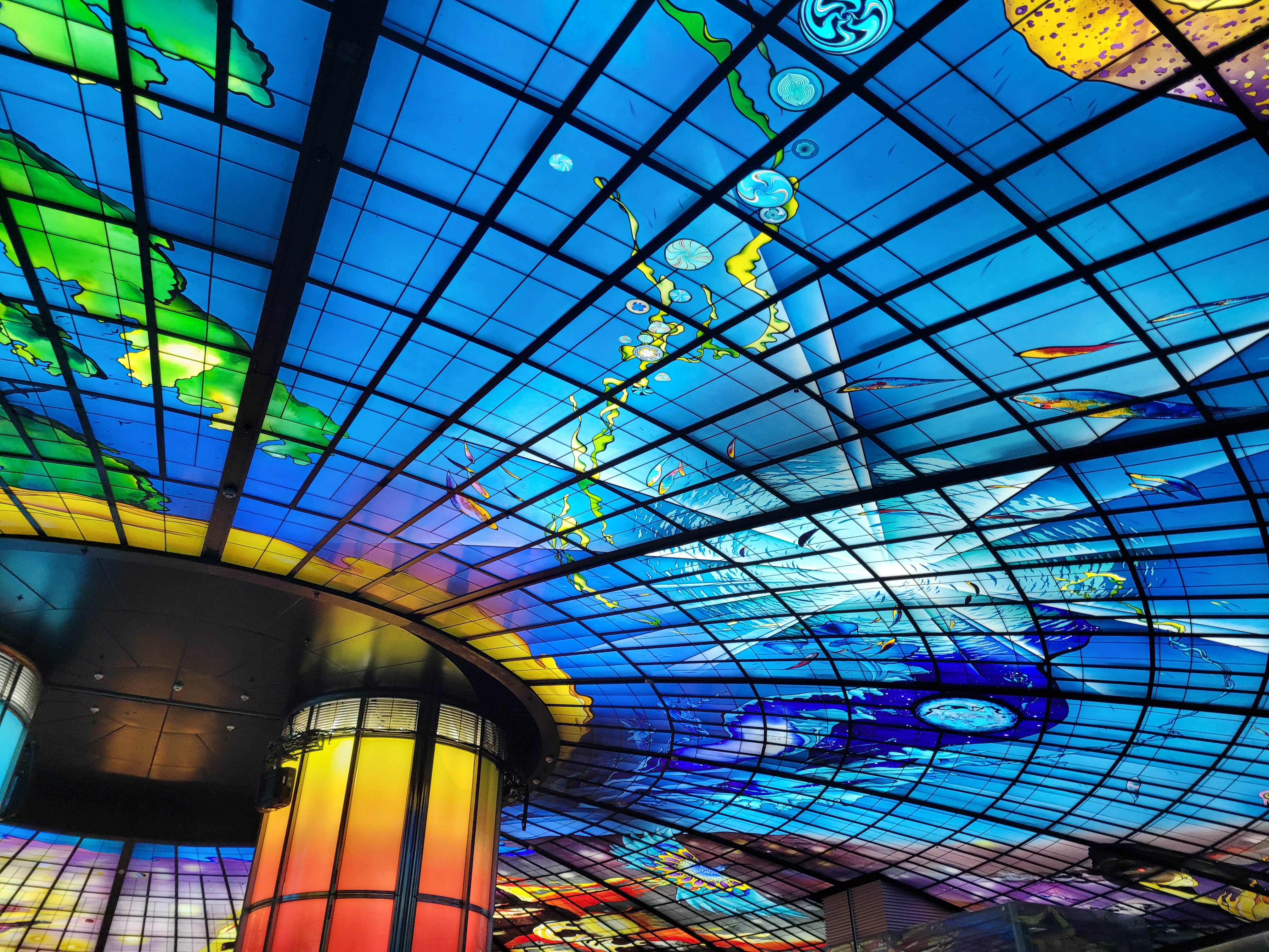06/04/2025 - The Dome of Light -
					The Dome of Light is a large stained glass installation located in the Formosa Boulevard MRT station in Kaohsiung.
					It was designed by the Italian artist Narcissus Quagliata and is one of the largest glass installations in the world.
					The dome is 30 meters in diameter and consists of 4,500 illuminated glass panels, taking 4 years to be completed.
					The installation is divided into four sections representing the birth, growth, glory and dimming of the cosmos.