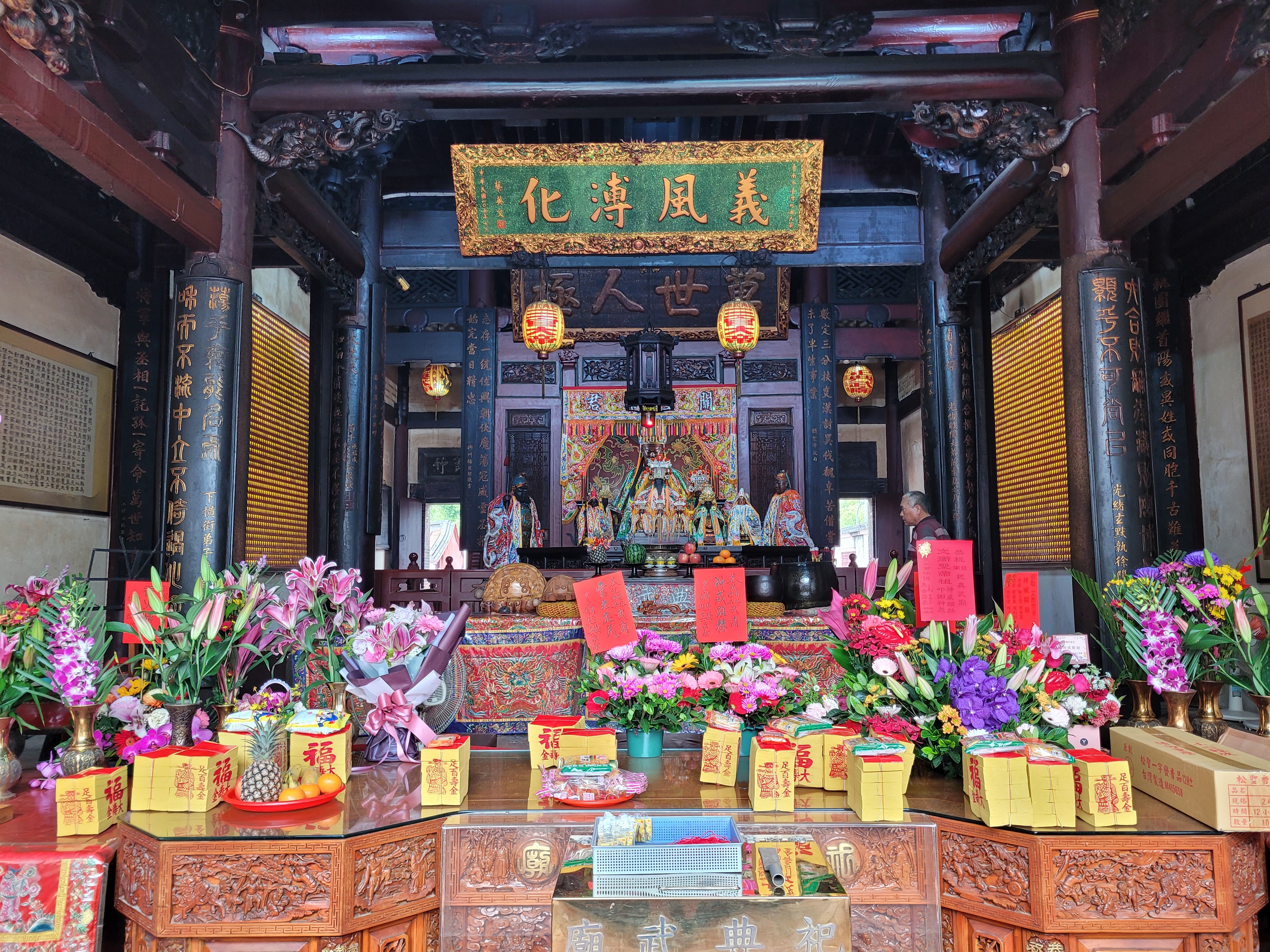 08/04/2025 - Inside Tainan Grand Mazu Temple -
					This temple is dedicated to Mazu, the goddess of the sea.
					We can see offerings to the goddess, including flowers, fruits, and false money that are burned to send to the goddess.