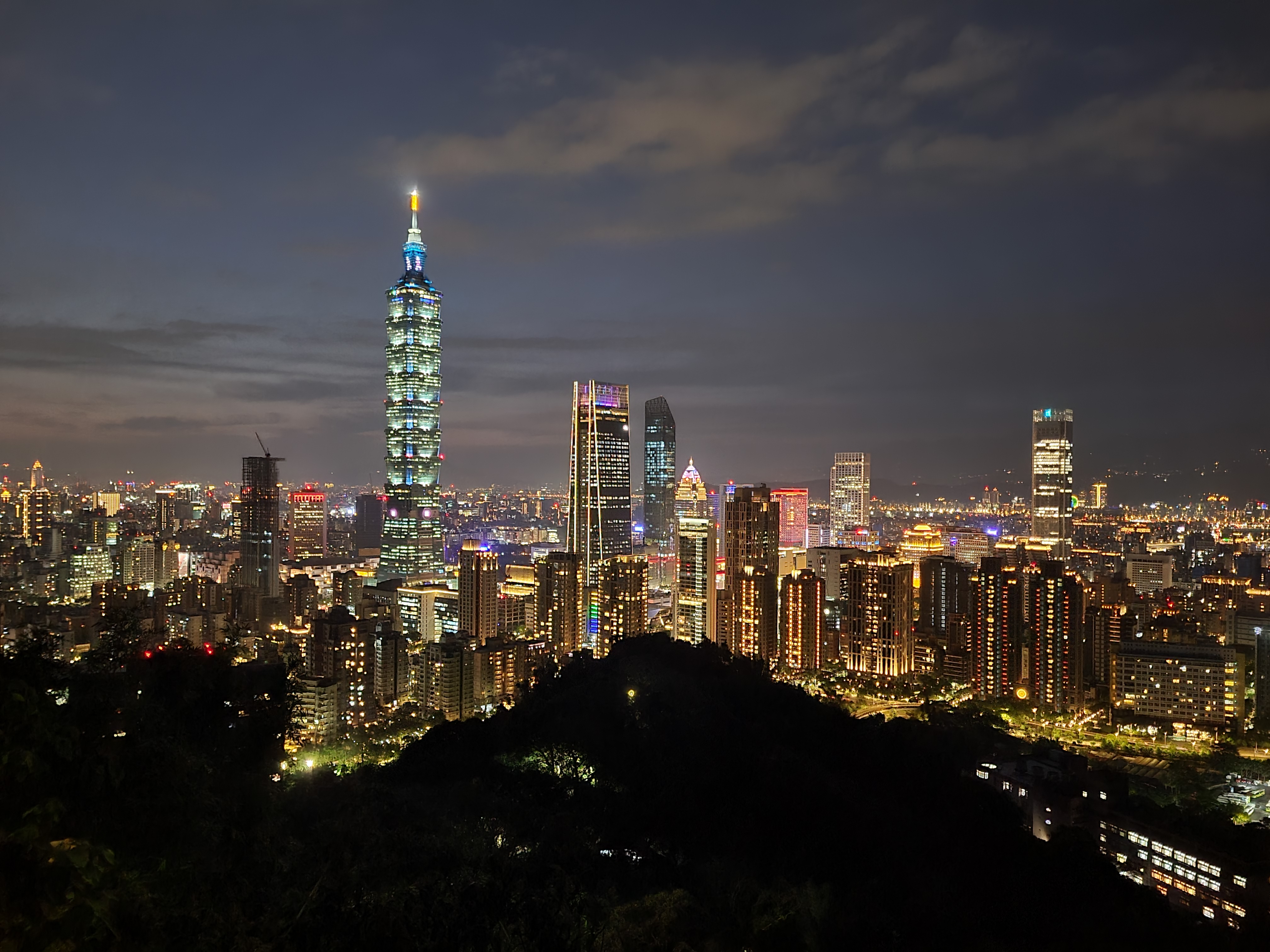 15/05/2025 - Night view of Taipei -
								Taken on the Elephant Mountain, the night view of Taipei has a lot of lights and colors.
								At the time of the picture it was the day of the Taipei 101 Marathon, which takes place every year.
								Participants have to climb the 91 floors of the Taipei 101 tower which is equivalent to 2046 steps.
								So that's why we can see a little boy running on the top screen of the tower.
								Usually the night, the tower is illuminated with a color that depends on the day of the week, a different color for each day.